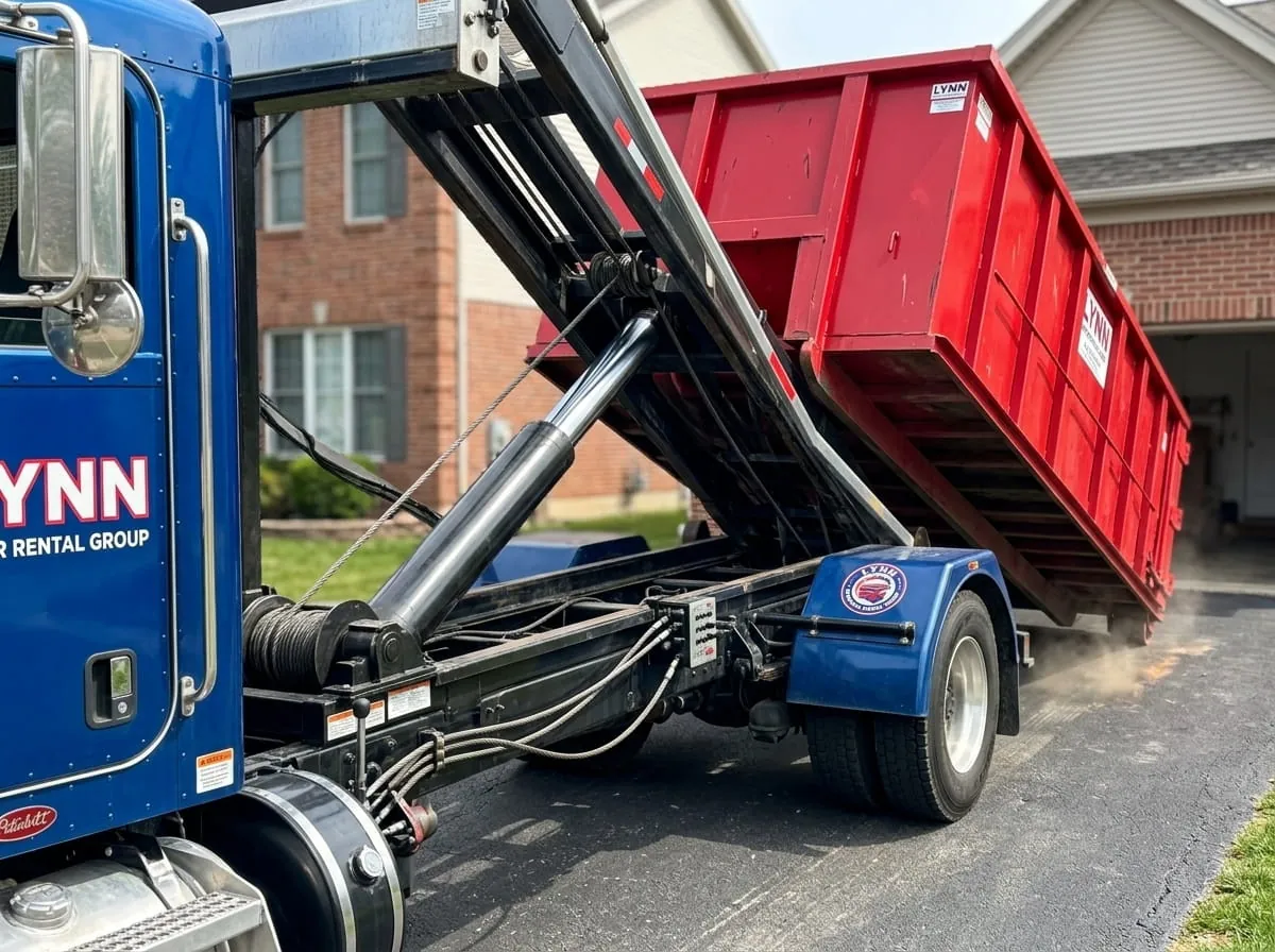 Heavy demolition dumpster being loaded onto a truck in Lynn, MA